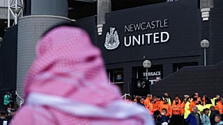 A man with a Saudi Arabian headdress pases by St. James' Park in Newcastle.