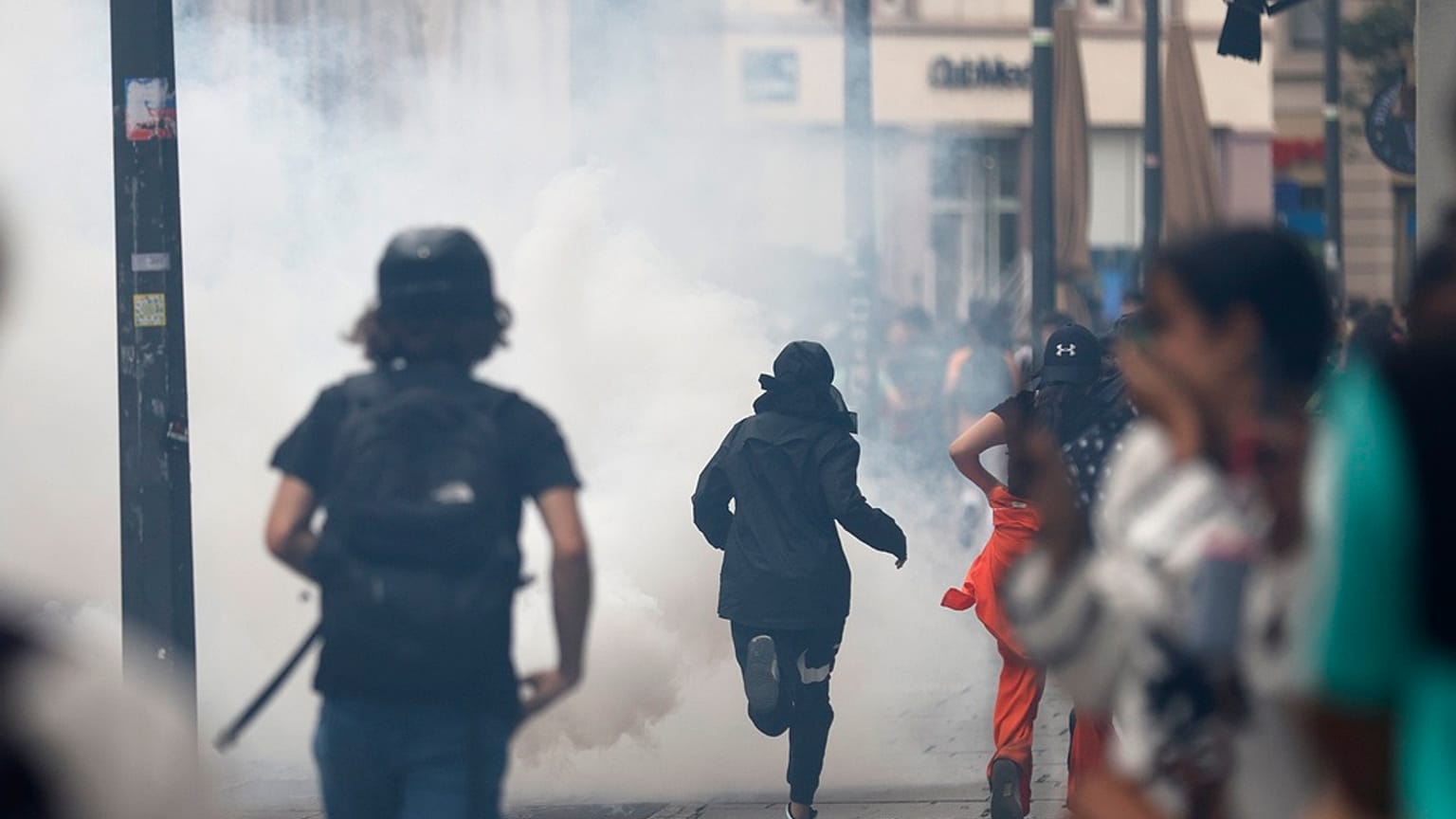 Youths run away during clashes with police forces Friday, June 30, 2023 in Strasbourg, eastern France. French President Macron urged parents Friday to keep teenagers at home.