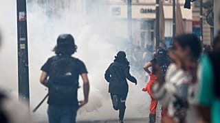 Youths run away during clashes with police forces Friday, June 30, 2023 in Strasbourg, eastern France. French President Macron urged parents Friday to keep teenagers at home.