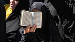 Iráni tüntető a Korán egy példányát tartja a magasba a svéd nagykövetség előtt Teheránban, 2023. június 30-án