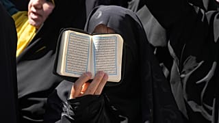 Iráni tüntető a Korán egy példányát tartja a magasba a svéd nagykövetség előtt Teheránban, 2023. június 30-án
