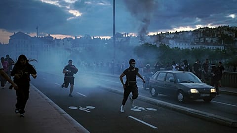 People run away during clashes with police in the center of Lyon, central France, Friday, June 30, 2023.