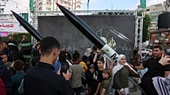 بلتقط الناس الصور مع الأسلحة في المعرض، غزة، 30/06/2023