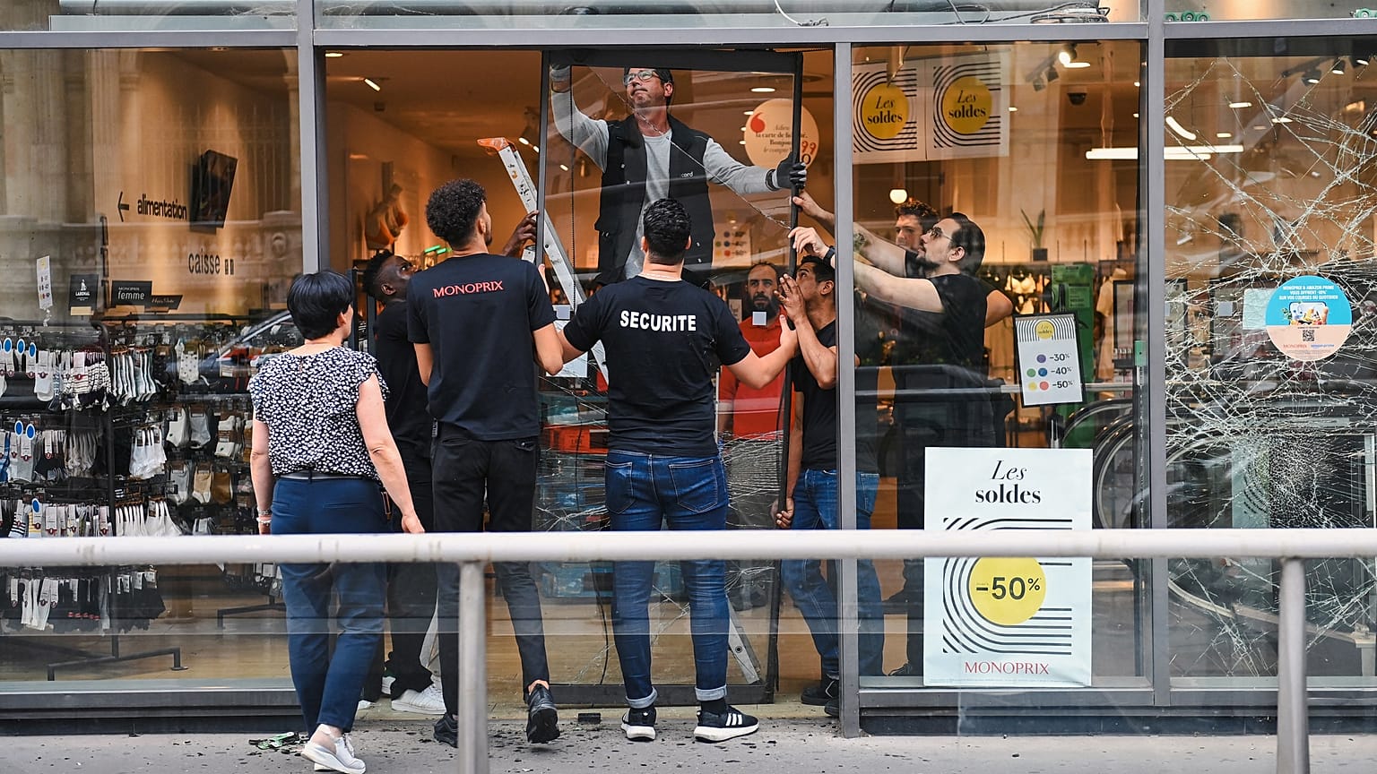 Сотрудники магазина Monoprix в центра Лиона снимают разбитые стеклянные двери