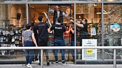 Сотрудники магазина Monoprix в центра Лиона снимают разбитые стеклянные двери