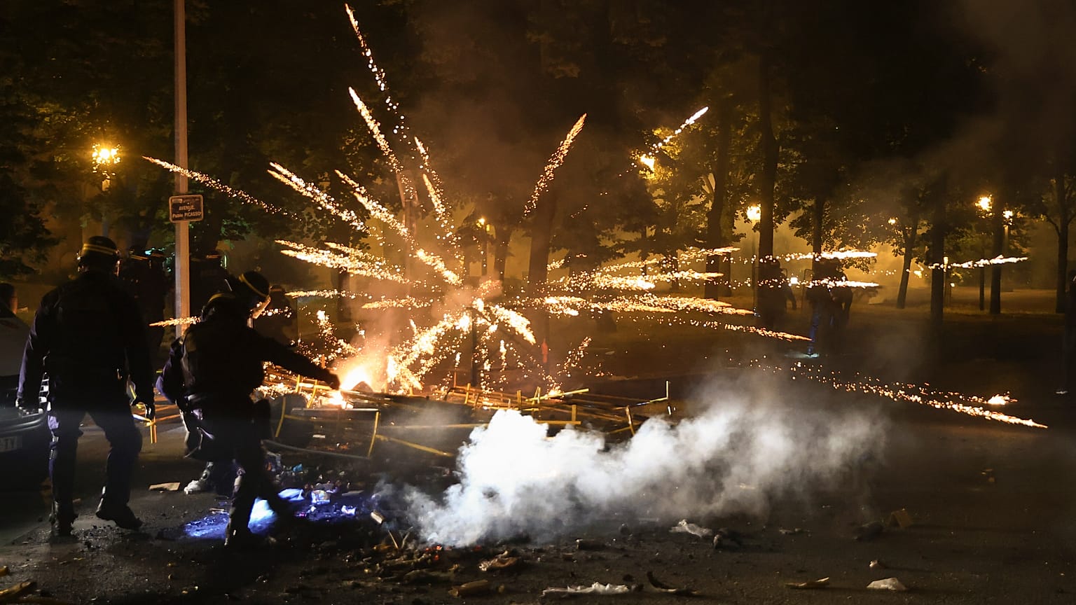 Police clear a street on the third night of protests sparked by the fatal police shooting of a 17-year-old driver in the Paris suburb of Nanterre, France.