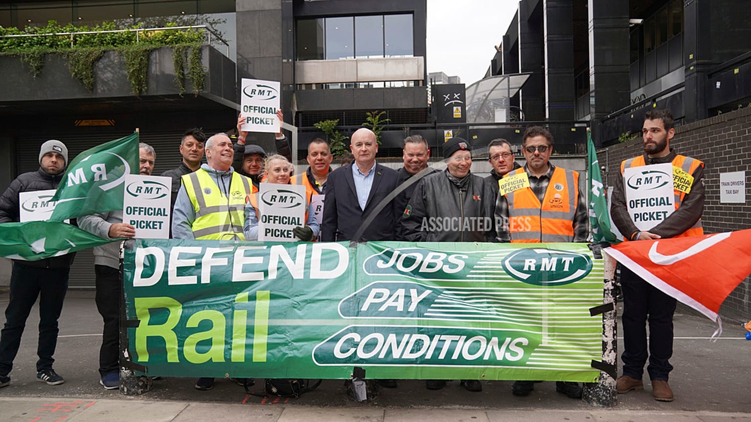 Rail, Maritime and Transport union general secretary Mick Lynch, center, joins members of his union on the picket line outside Euston train station, London.