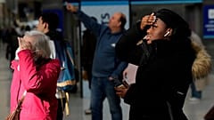 Reisende schauen auf die Anzeigetafel der Züge in der Londoner Waterloo Station