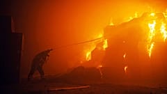 A firefighter puts out fire as a result of falling debris after a drone attack. 