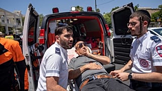 Mentősök szállítják el a gázolásos támadás egyik sérültjét Tel Avivban