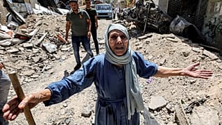 امرأة مسنة تعرب عن فاجعتها وهي تقف على أنقاض الرصيف المكسور على طول زقاق في جنين بالضفة الغربية المحتلة. 2023/07/05