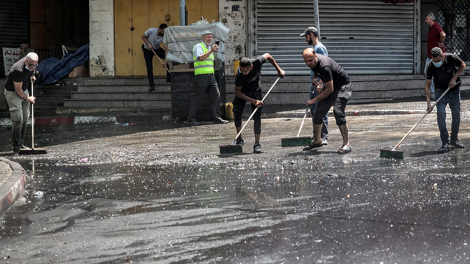 Vecinos del campamento de refugiados de Yenín limpian los escombros tras la incursión israelí. 