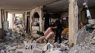 Palestinianos inspecionam casa danificada no campo de refugiados de Jenin, na Cisjordânia, esta quarta-feira.