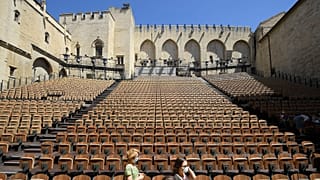 People stand in the "Cour d'honneur" of the Popes' Palace (Palais des papes) stage on the first day of this year edition of the Avignon theatre festival in Avignon in 2021