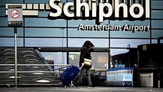 A women pulls a suitcase in high winds outside Schiphol airport, Amsterdam.