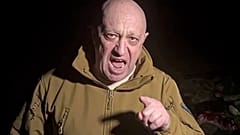 Wagner group leader Yevgeny Prigozhin stands in front of multiple bodies lying on the ground in an unknown location in March 2023.