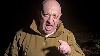 Wagner group leader Yevgeny Prigozhin stands in front of multiple bodies lying on the ground in an unknown location in March 2023.