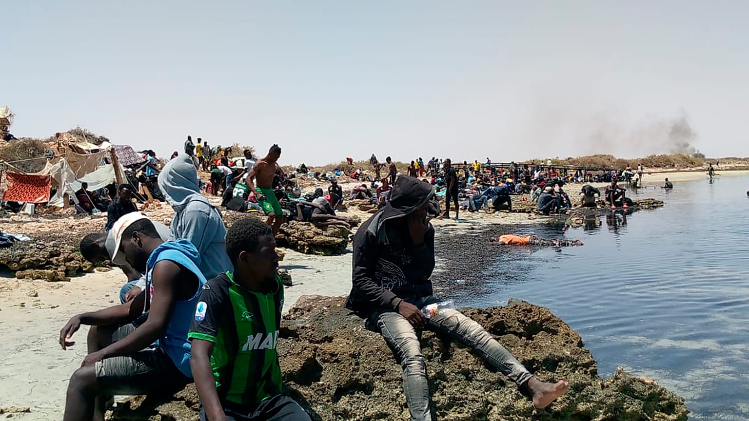 عدد من المهاجرين الأفارقة من جنوب الصحراء عالقين على شاطئ يُزعم أنه يقع على الحدود التونسية الليبية 