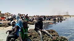 عدد من المهاجرين الأفارقة من جنوب الصحراء عالقين على شاطئ يُزعم أنه يقع على الحدود التونسية الليبية 