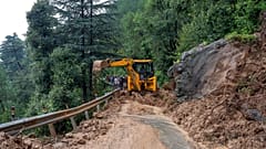 Ein riesiger Felsbrocken rollt auf eine Straße herab und zerquetscht drei Autos. 