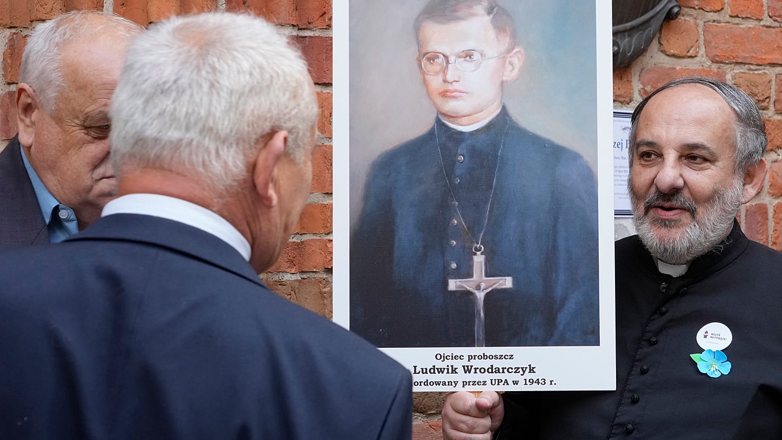  People hold portrait of a Polish parish priest murdered by Ukrainian nationalists in 1943 during a reconciliation service in Warsaw. 7 July 2023