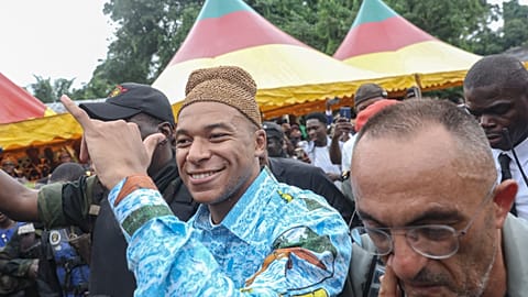 Kylian Mbappe (C) vêtu d'un vêtement traditionnel lors d'une visite au village de son père, Wilfrid Mbappe, à Djebale au Cameroun, le 8 juillet 2023.