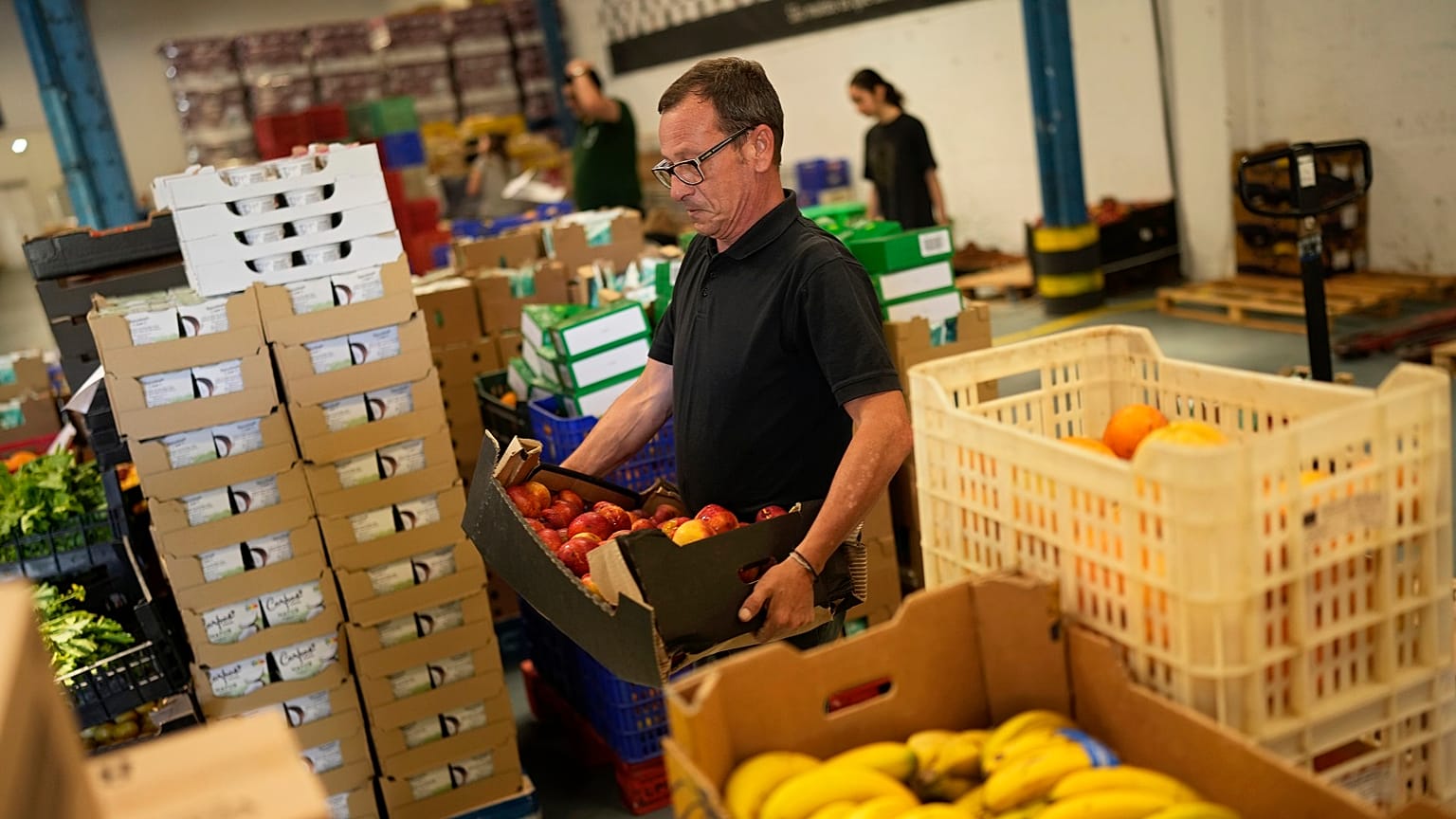 Voluntarios clasifican alimentos que se distribuirán a organizaciones benéficas en un almacén del Banco de Alimentos contra el Hambre en Lisboa, el jueves 1 de septiembre de 2022.