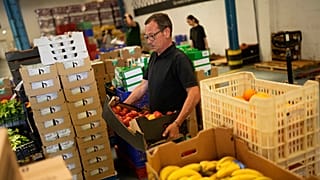 Voluntarios clasifican alimentos que se distribuirán a organizaciones benéficas en un almacén del Banco de Alimentos contra el Hambre en Lisboa, el jueves 1 de septiembre de 2022.