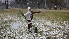 Un niño juega con la nieve