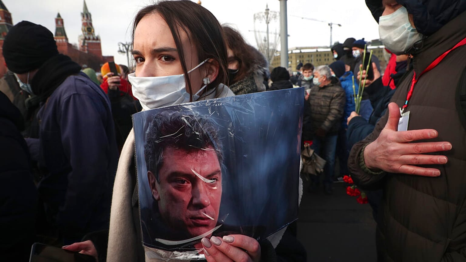 FILE: A woman holds a portrait of Boris Nemtsov near the spot where Russian opposition leader was gunned down, in Moscow, Russia on Feb. 27, 2021.