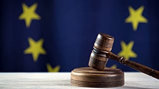 عکس تزئینی از پرچم اتحادیه اروپا و چکش دادگاه