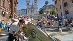Mann erfrischt Hund an der Spanischen Treppe in Rom