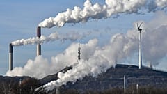 A Uniper coal-fired power plant and BP refinery steam beside a wind generator in Gelsenkirchen, Germany