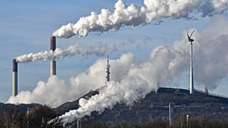 A Uniper coal-fired power plant and BP refinery steam beside a wind generator in Gelsenkirchen, Germany