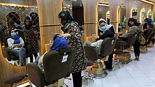 Beauticians put makeup on customers at Ms. Sadat's Beauty Salon in Kabul