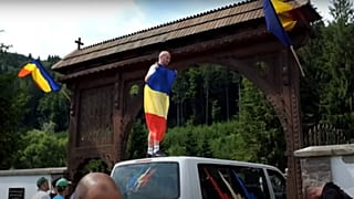 A temető kapujára felmászva román lobogókat tettek ki - 2023. júl. 9.