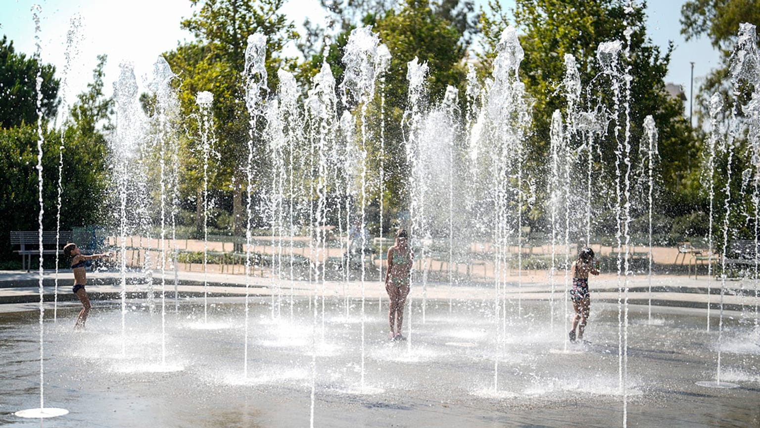 Des enfants jouent dans une fontaine d'eau pendant une vague de chaleur, au centre culturel de la fondation Stavros Niarchos à Athènes.; le 13 juillet 2023