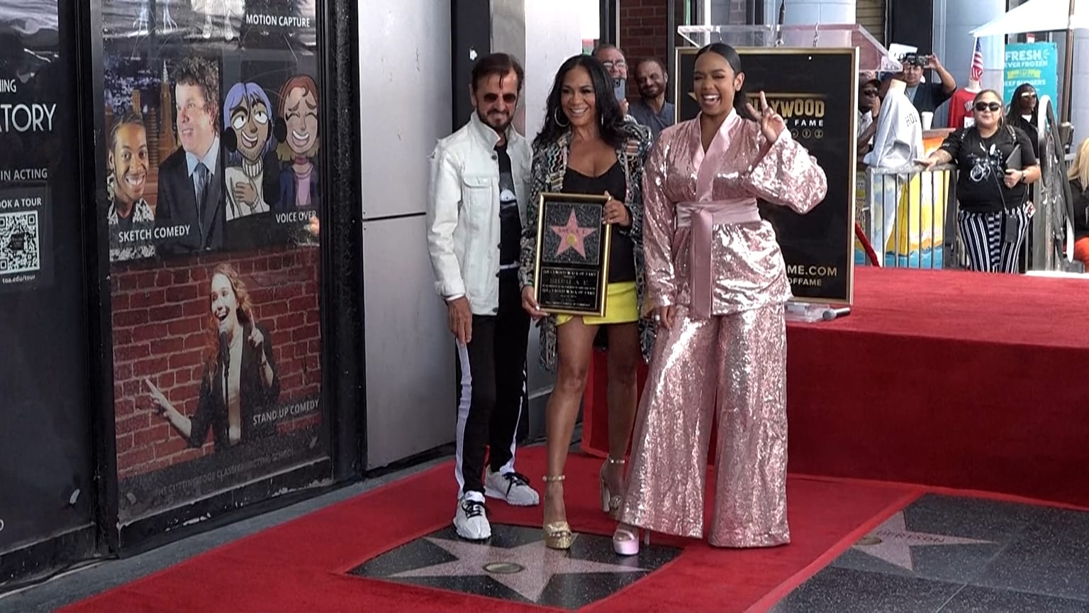 Mid shot (left to right) drummer Ringo Starr, Sheila Cecilia Escovedo, and singer H.E.R. posing on the star for the photographers.