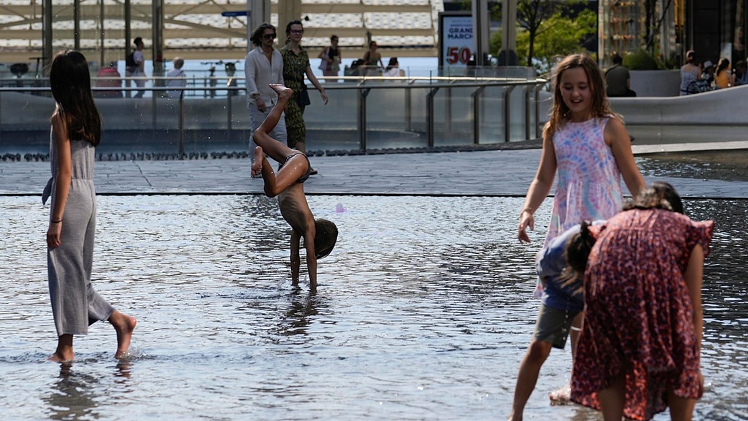 Kinder kühlen sich in Mailand am 15. Juli 2023