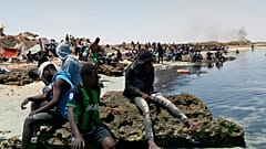 Migranten warten an der Grenze zwischen Tunesien und Libyen am 6. JUli 2023