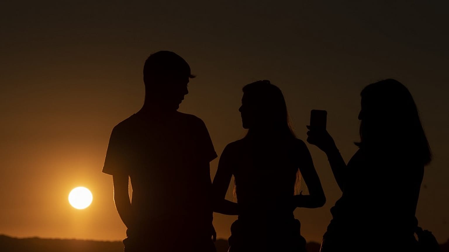 Des personnes profitent du coucher du soleil à Ronda dans le sud de l'Espagne, le 15 juillet 2023. 
