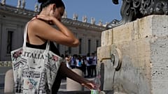 Turistler İtalya'nın Milano kentinde halka açık bir çeşmede serinliyor.