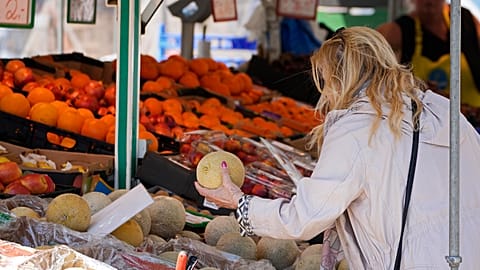 A woman checks the price of a water melon in Essen, Germany, Wednesday, May 31, 2023. 