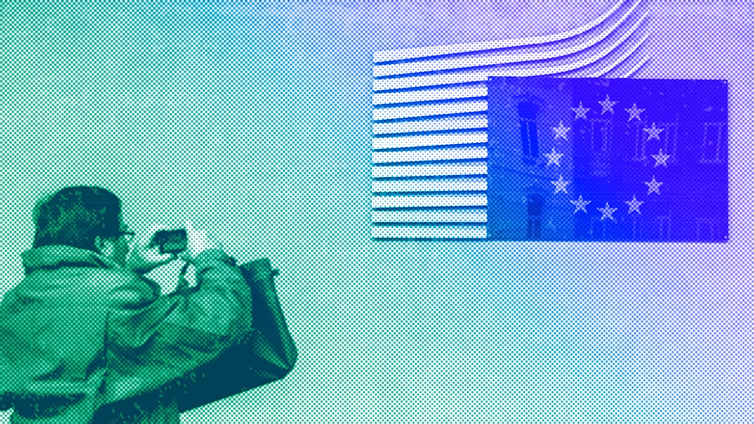  A man takes a picture of the European flag at the European Commission headquarters in Brussels, October 2012