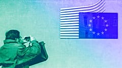  A man takes a picture of the European flag at the European Commission headquarters in Brussels, October 2012