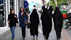 FILE - Iranian women make their way along a sidewalk in downtown Tehran, Iran, Tuesday, April 26, 2016. 