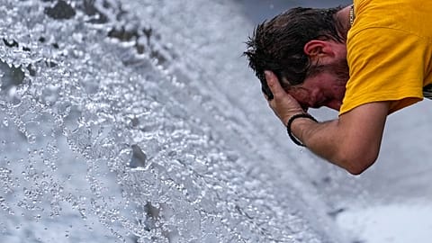 A man cools off at a fountain during a sunny day in Belgrade, Serbia