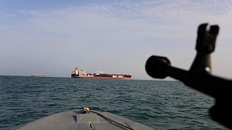 FILE - A July 21, 2019 photo of a speedboat of Iran's Revolutionary Guard training a weapon toward the British-flagged oil tanker Stena Impero, seized in the Strait of Hormuz.
