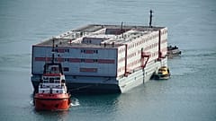 Tug boat Mercia pulls the Bibby Stockholm accommodation barge into Portland in Dorset where it is due to house migrants.