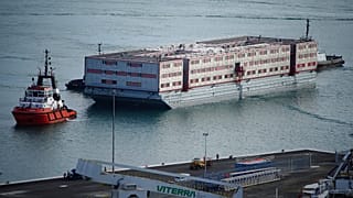 Tug boat Mercia pulls the Bibby Stockholm accommodation barge into Portland in Dorset where it is due to house migrants after travelling from dry dock in Falmouth, UK.
